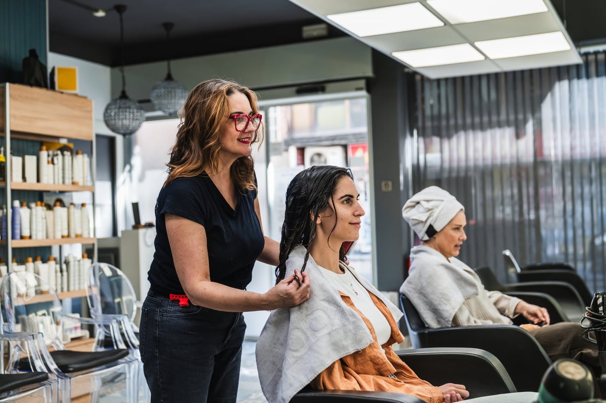 Hairdresser preparing a client's hair for a beauty treatment in a modern salon