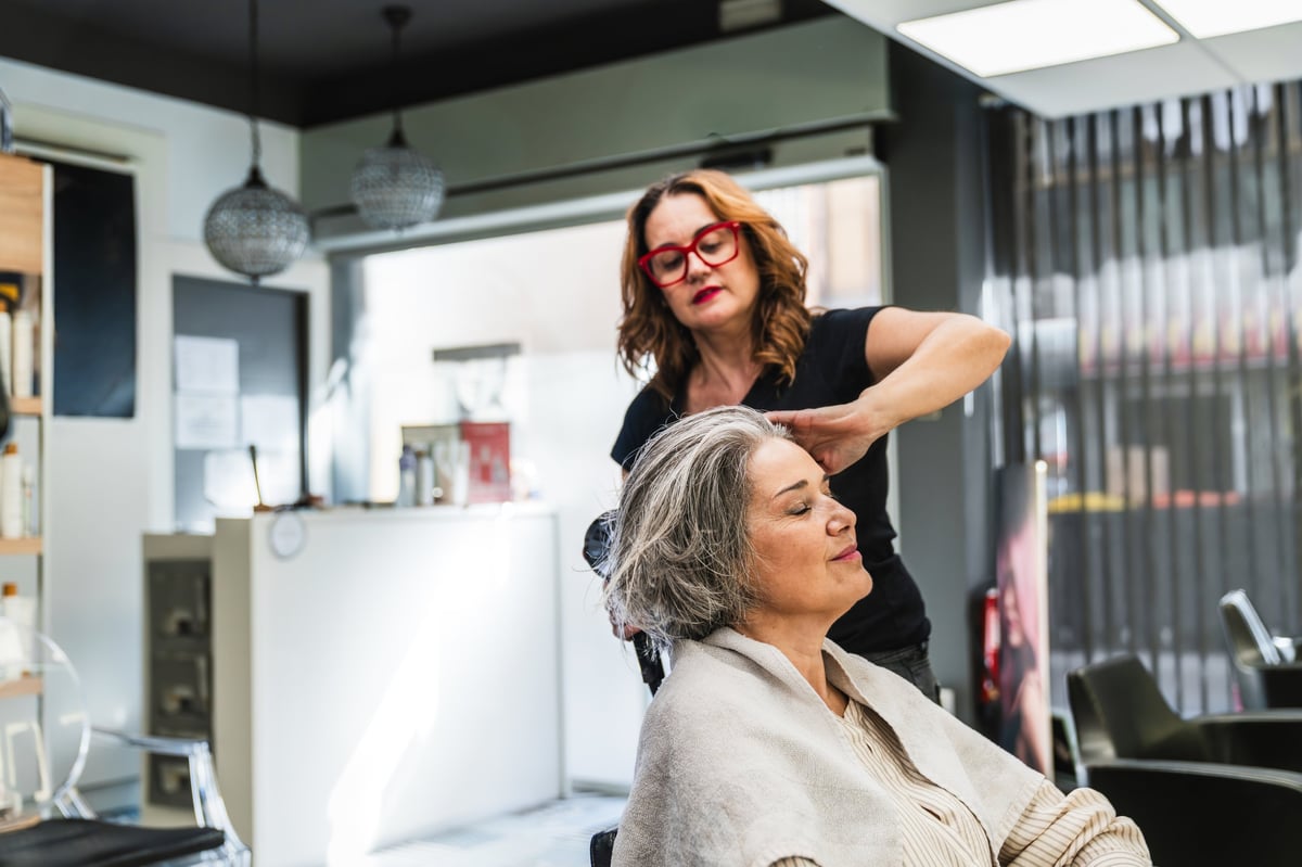 Hairstylist blow-drying and styling a client's hair